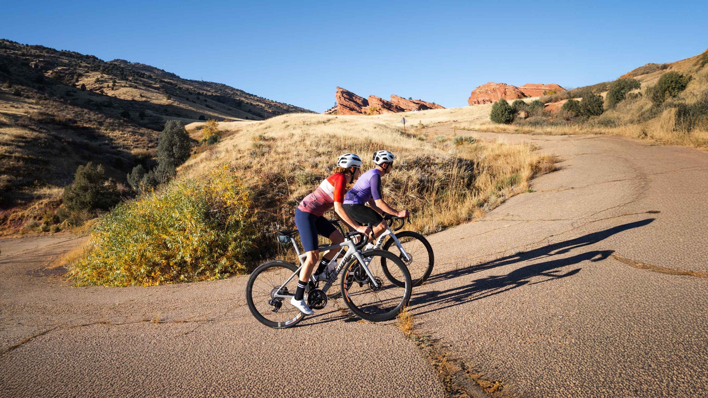 Cyclist riding in Red Rocks Park, Morrison Colorado, wearing summer jerseys and shorts.