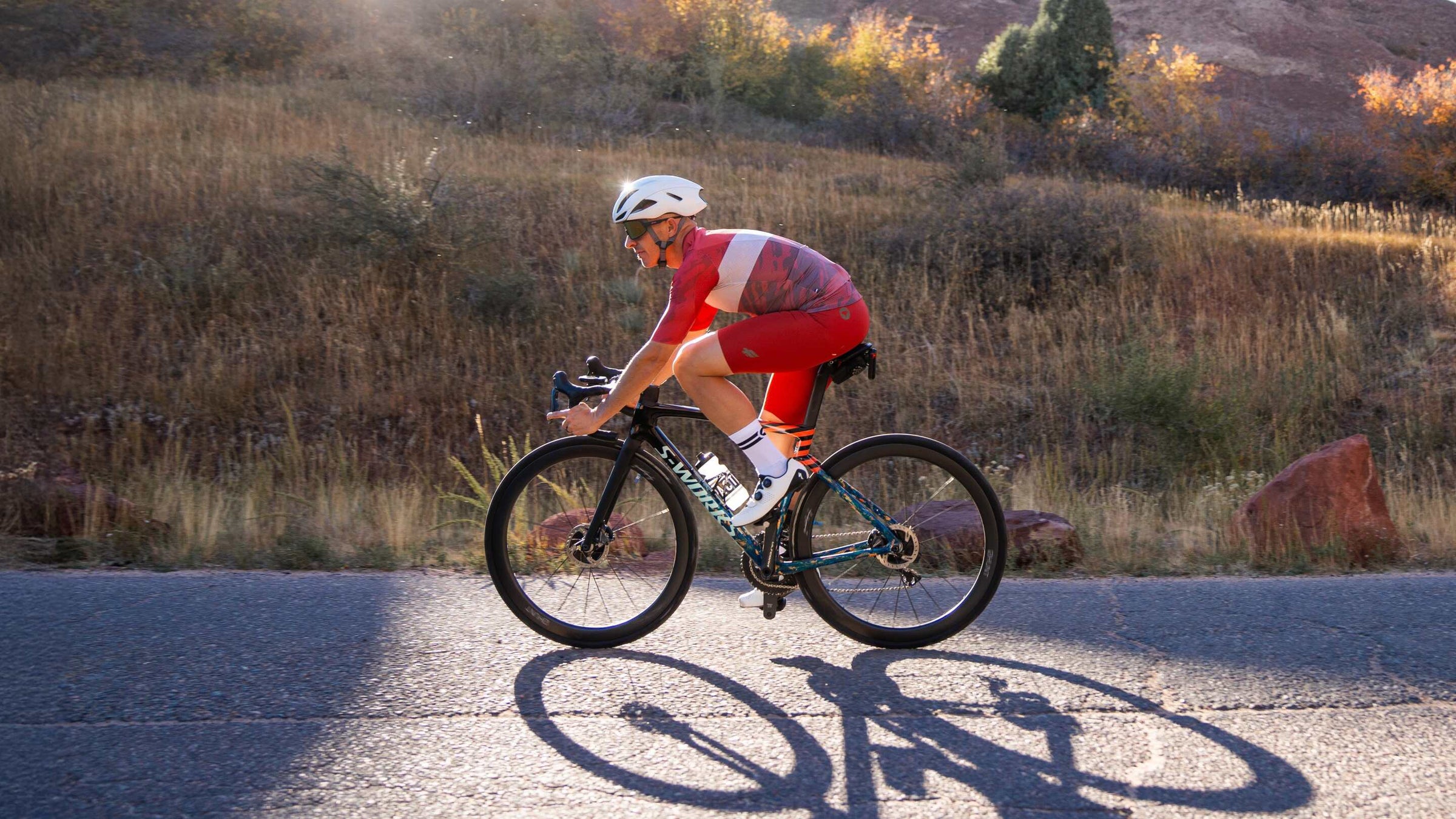 male cyclist wearing red cycling bib shorts  and a red cycling jersey on S-Works bike